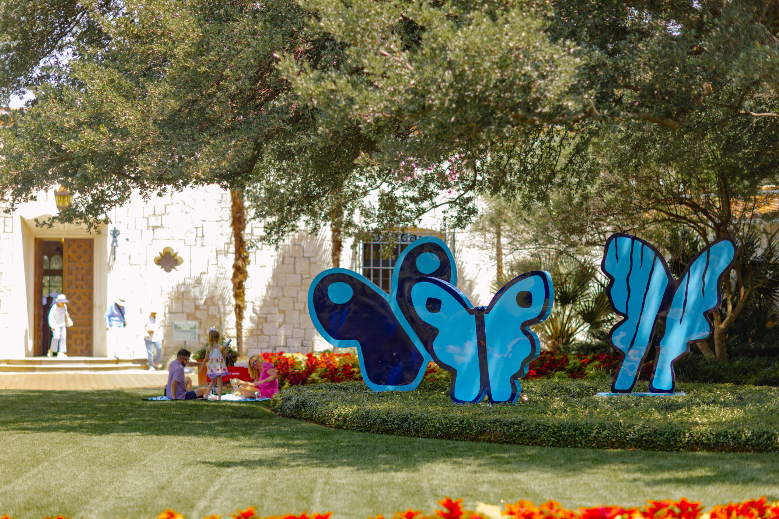Guests enjoy a picnic beside Hunt Slonem's Kaleidoscope State II,Ivy Trio sculptures at the Dallas Arboretum.